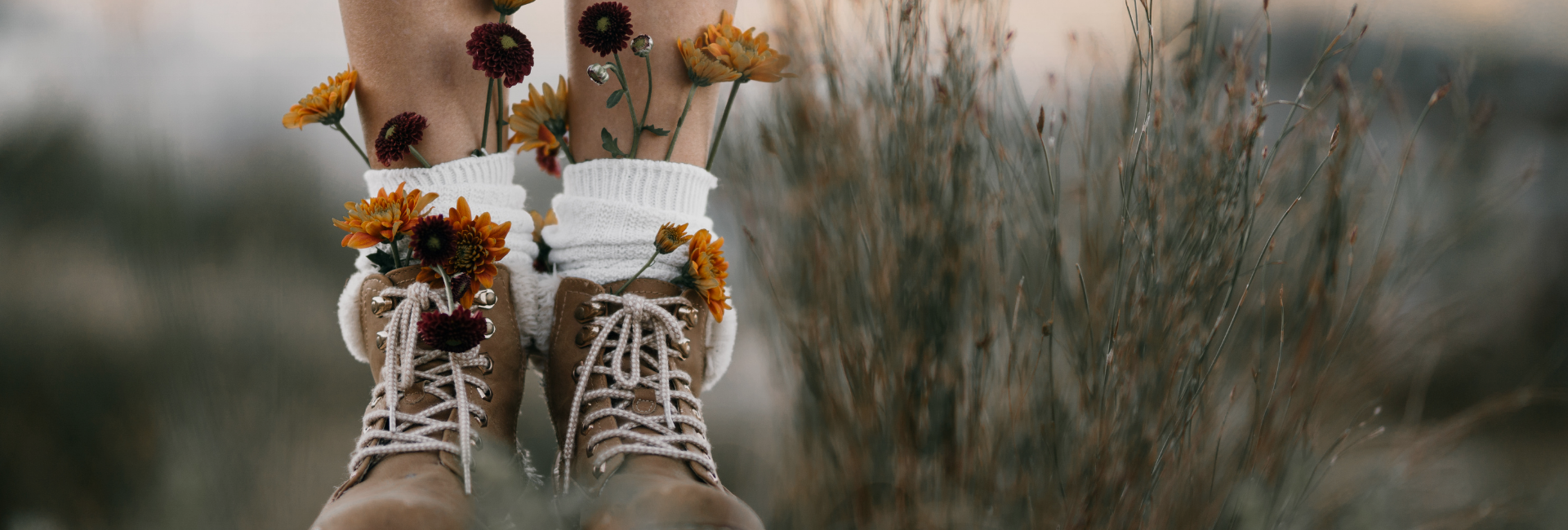 Zwei Paar Wanderstiefel mit Blumen, Sinnbild für den gemeinsamen Weg eines Paares
