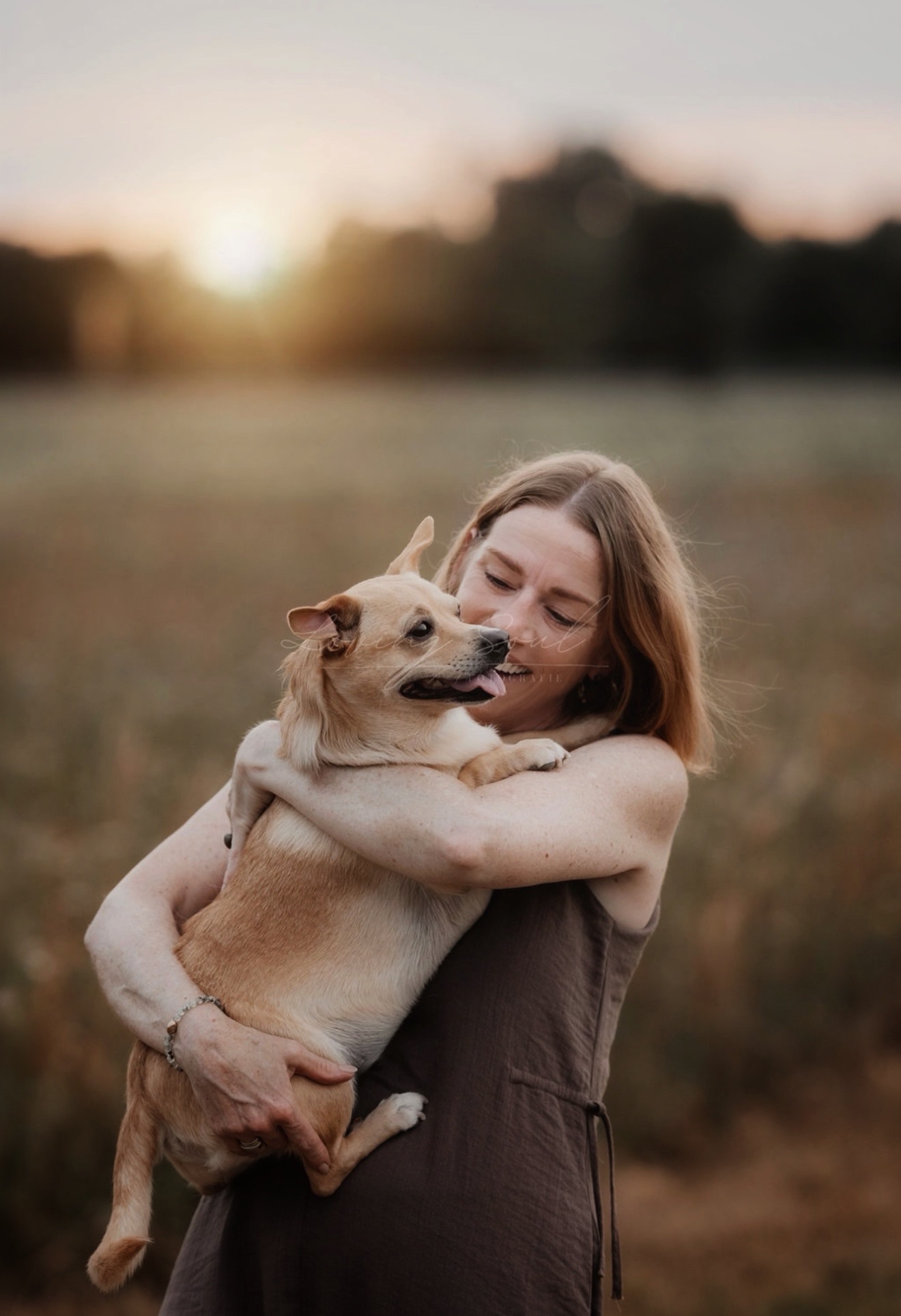 Sandra Werner mit ihrem Hund Max auf einem Feld im Abendlicht