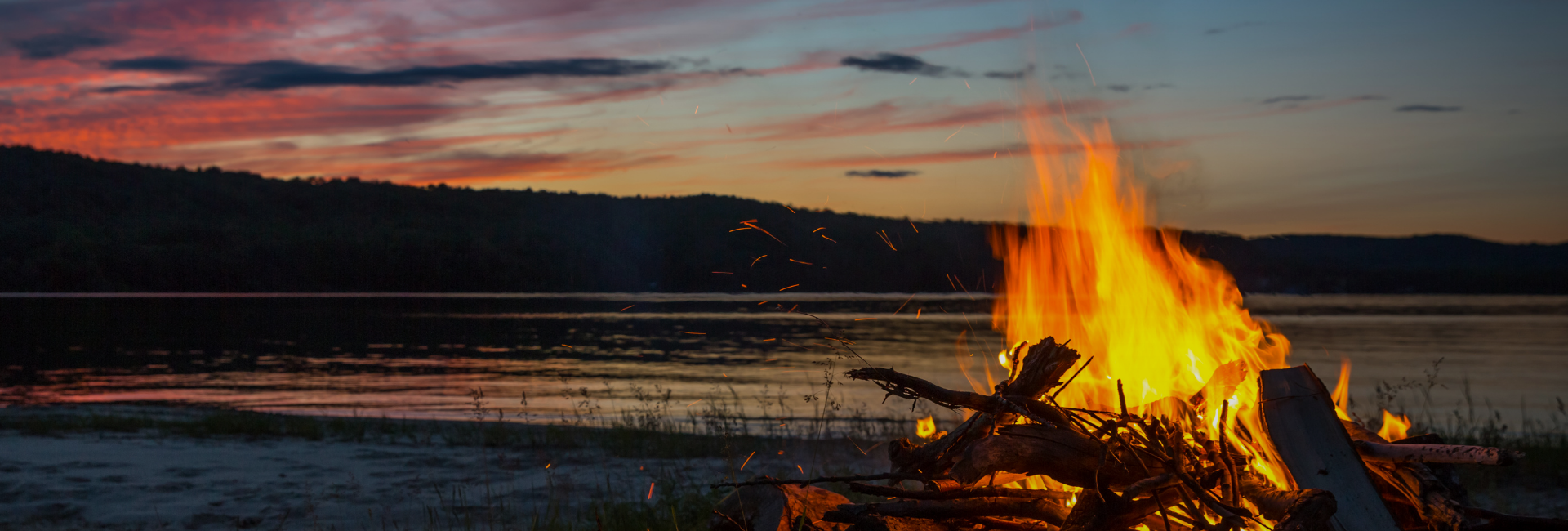 Ruhiges Lagerfeuer im warmen Abendlicht als Sinnbild für gemeinsames Erinnern